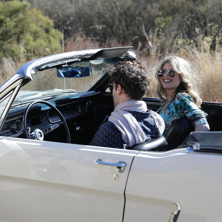 woman and man driving in fancy car